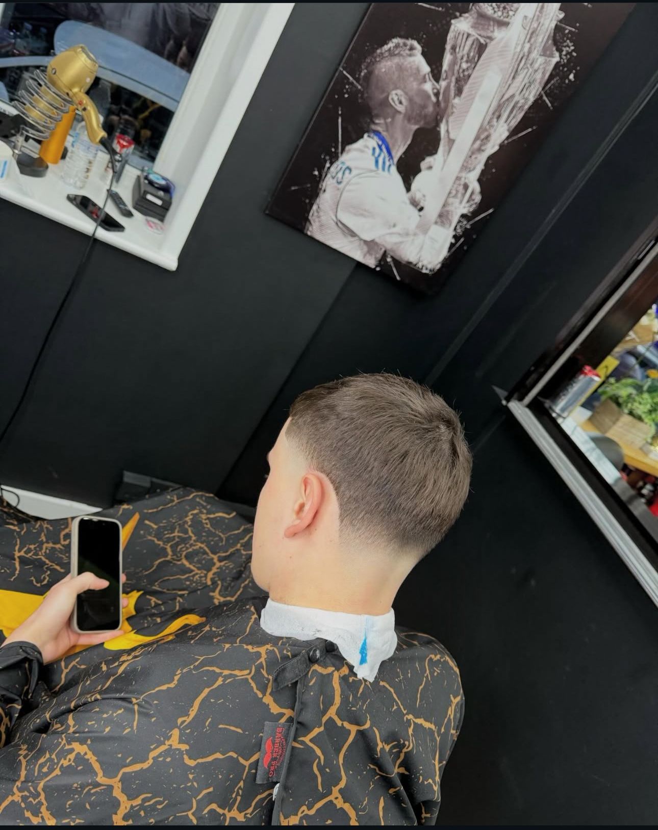 A barber working on a client's hair at TAHO BARBERS